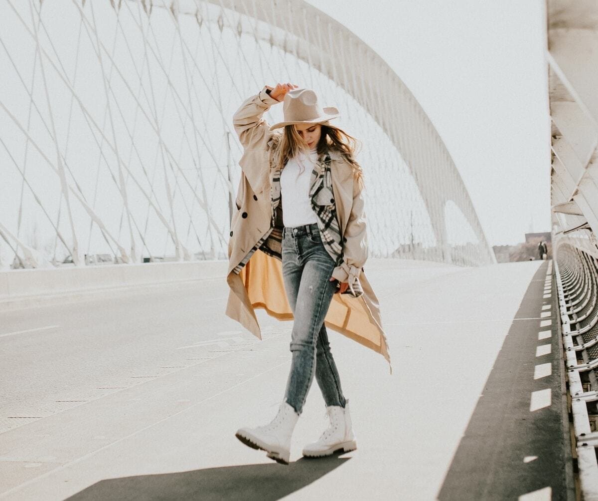 kobieta w kapeluszu idzie po moście